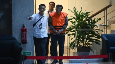 Tersangka Risna Sutriyanto (kanan) berjalan menuju mobil tahanan usai menjalani pemeriksaan di gedung Merah Putih KPK, Jakarta, Senin (11/8/2025). Komisi Pemberantasan Korupsi (KPK) menahan tersangka baru seorang aparatur sipil negara Kementerian Perhubungan, Risna Sutriyanto terkait penyidikan kasus dugaan korupsi di lingkungan Direktorat Jenderal Perkeretaapian (DJKA) Kemenhub Tahun Anggaran 2018â2022 di wilayah Semarang. ANTARA FOTO/Sulthony Hasanuddin/bar (ANTARA FOTO/SULTHONY HASANUDDIN)